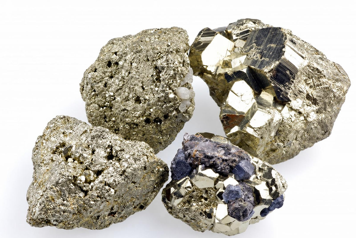 Four metallic gold-toned mineral clusters show glittering grains, angular faces and dark patches on white.