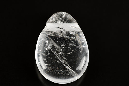 A clear quartz pendant shaped like a drop, containing dark inclusions and white streaks, set against a black background.