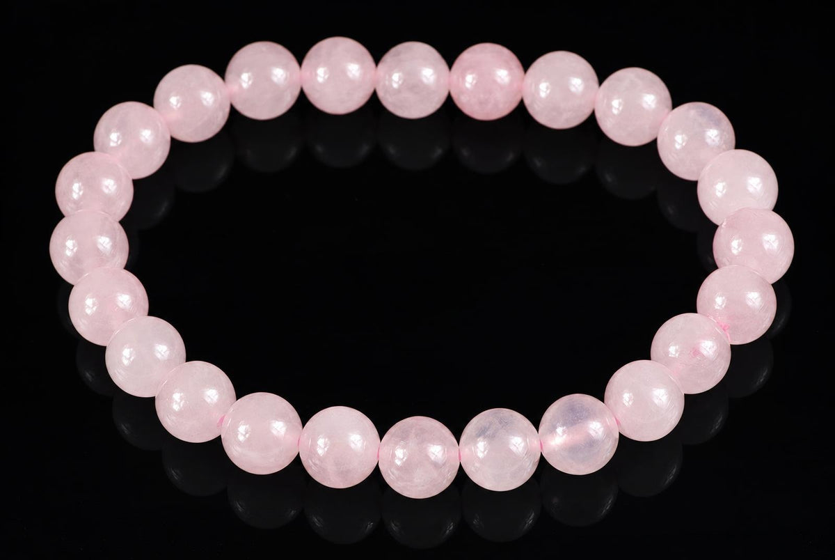 A bracelet of round, pale pink beads arranged in a circle on a dark surface.
