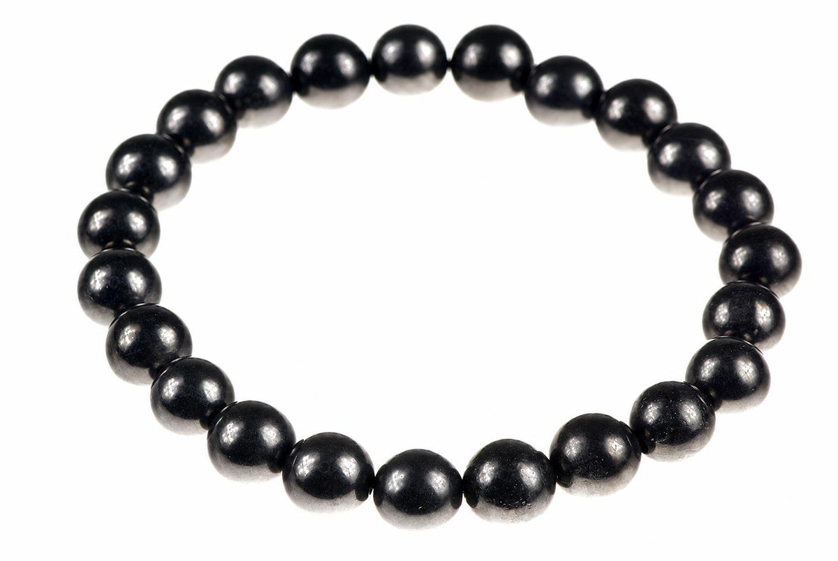 A bracelet made of round, dark black beads arranged in a circle on a white background.