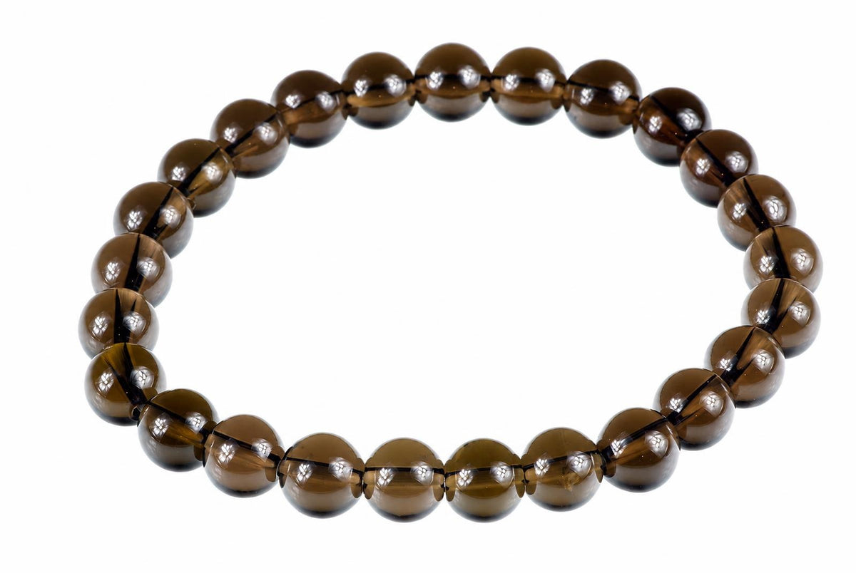 A bracelet of round, dark brown beads with a white background.
