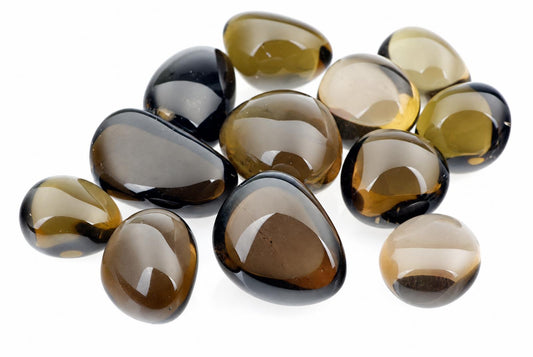 A pile of polished, smooth stones in dark brown and black tones on a white surface.
