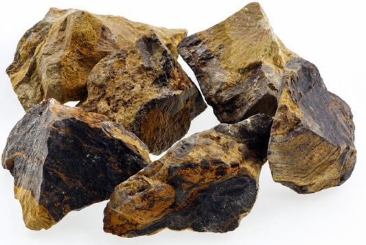 A pile of six rough, irregular rocks with dark brown and yellow-brown layered surfaces on a white background.