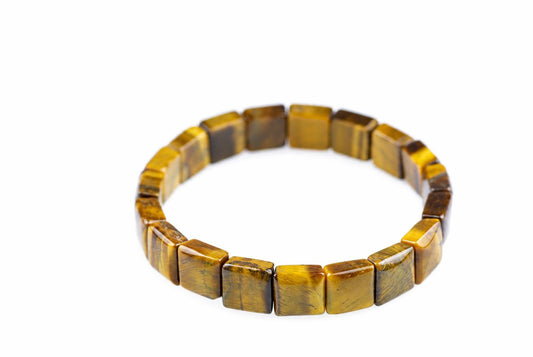 A bracelet made of square beads with a tiger eye pattern in yellow and brown, set against a white background.
