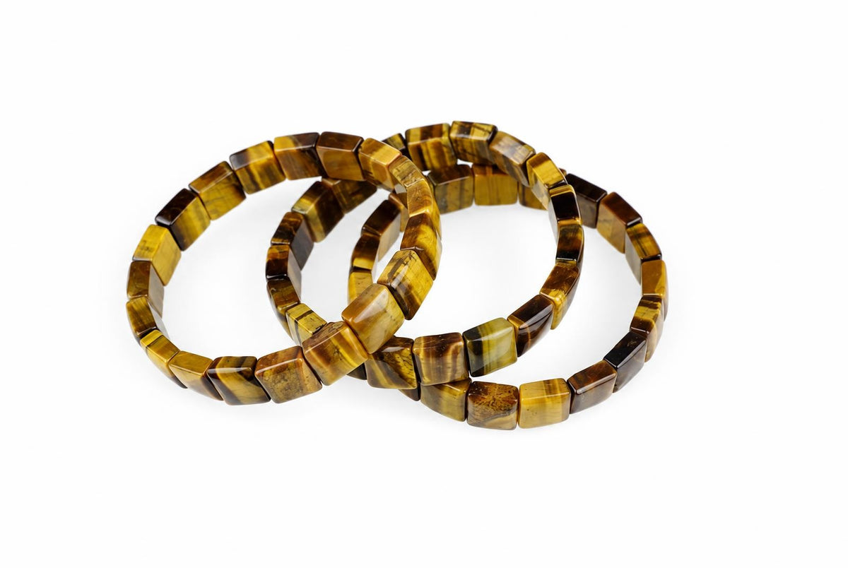 Three square tiger eye bracelets with yellow and brown stripes lie on a white surface.