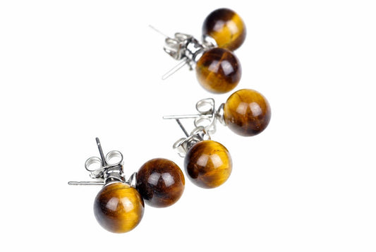 Three pairs of round golden-brown stud earrings with silvery posts are arranged diagonally on white.