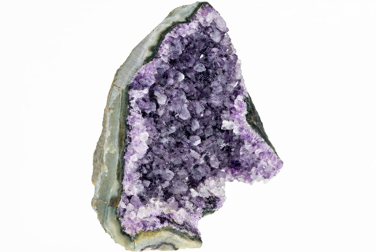 A geode slice with a rough grey-green outer rind and an interior cavity filled with purple and white amethyst crystals on a white background.