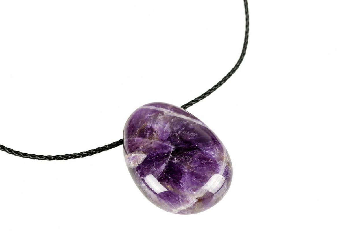 A polished purple amethyst pendant on a dark cord, set against a white background.