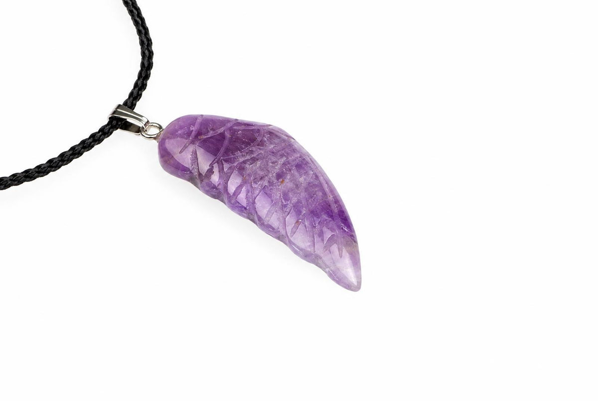 A purple amethyst pendant shaped like a wing, with internal crystalline patterns, attached to a black braided cord via a silver-toned bail.