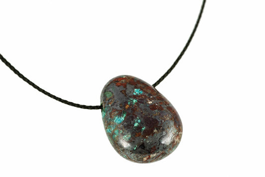 A polished teardrop chrysocolla pendant with blue and green patches on a dark brown surface hangs from a black cord against white.