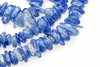 Blue kyanite chip beads arranged on a white surface.
