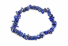 A bracelet of irregular blue stone chips with pale and gold-toned flecks forms a loop on a white background.