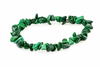 A bracelet made of irregular green malachite chips arranged in a circle on a white surface.