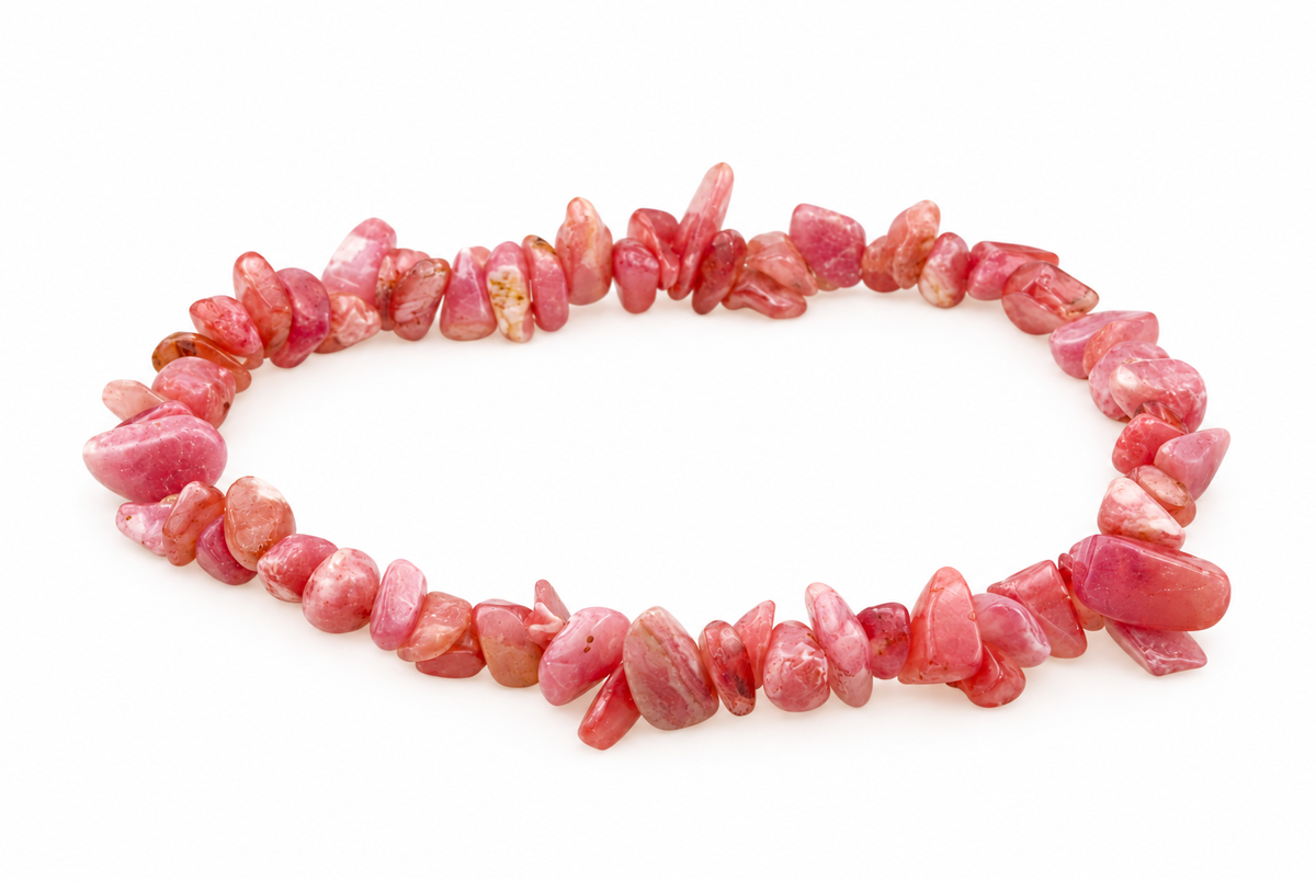 A bracelet made of irregular pink and reddish chips, possibly rhodochrosite, arranged in a circle on a white surface.