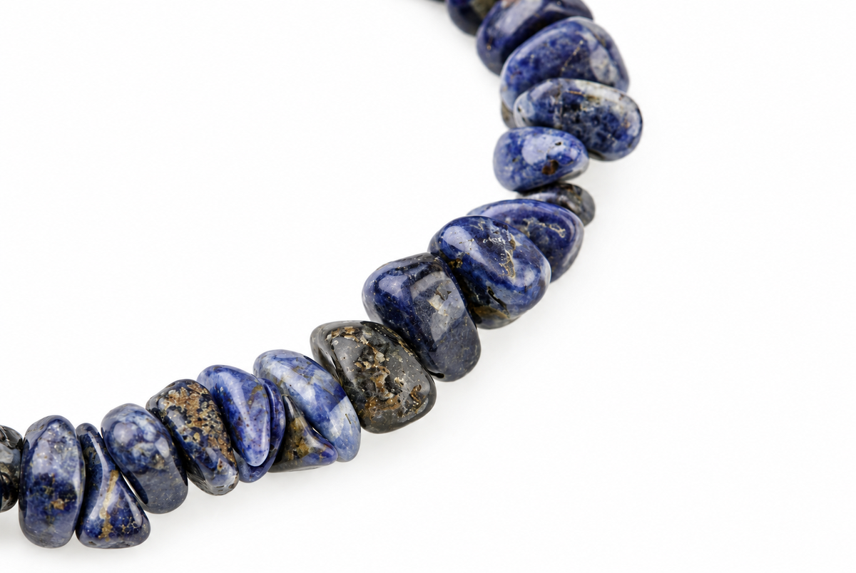 Close-up of polished blue, grey and white stone chips with mottled markings curving across a white background.