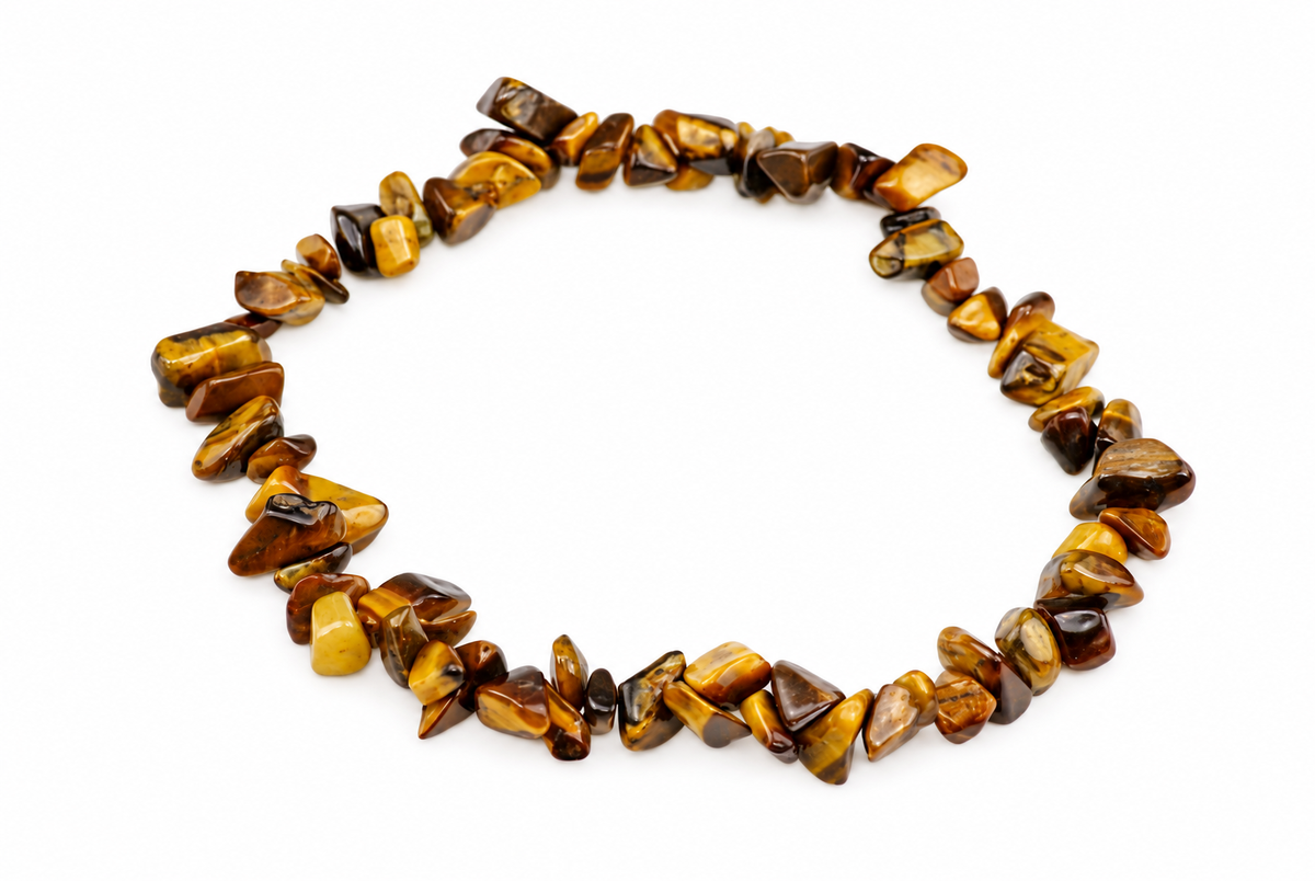 A bracelet of irregular polished golden-brown and dark stone chips forms a loop on a white surface.