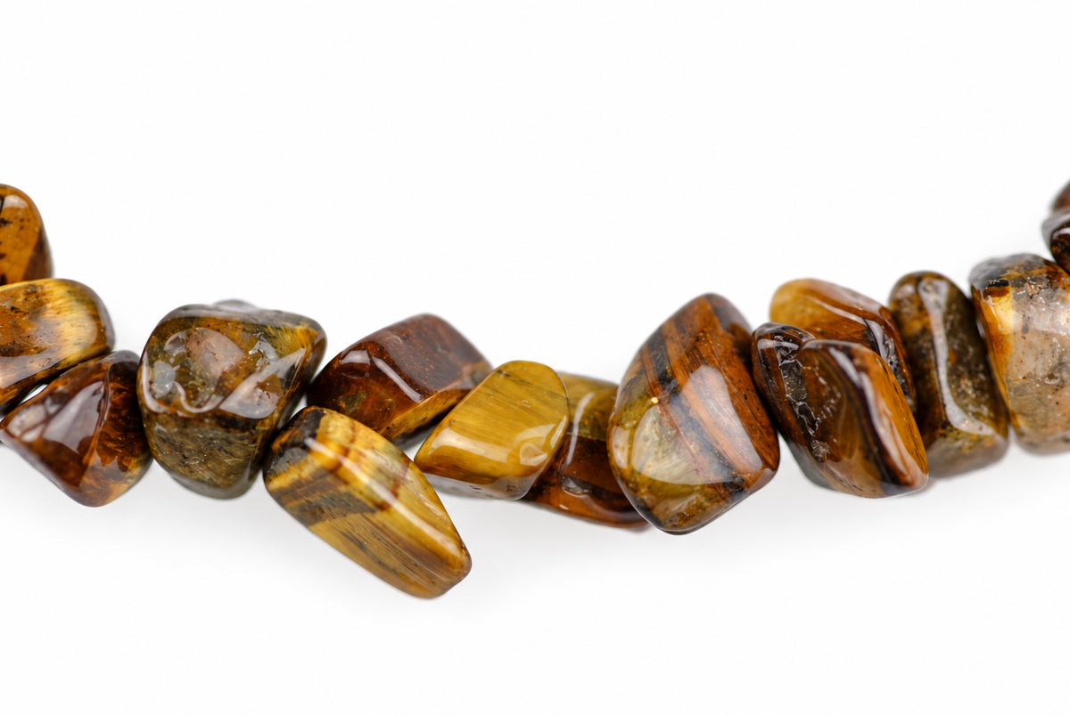 Close-up of irregular glossy stone chips with golden-brown and dark streaks against a white background.