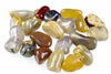 A collection of polished agate stones in various shapes and colours including yellow, brown, grey, black and white on a pale surface.