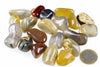 A collection of polished agate stones in various colours including yellow, brown, grey and black on a white surface with a one euro coin for scale.