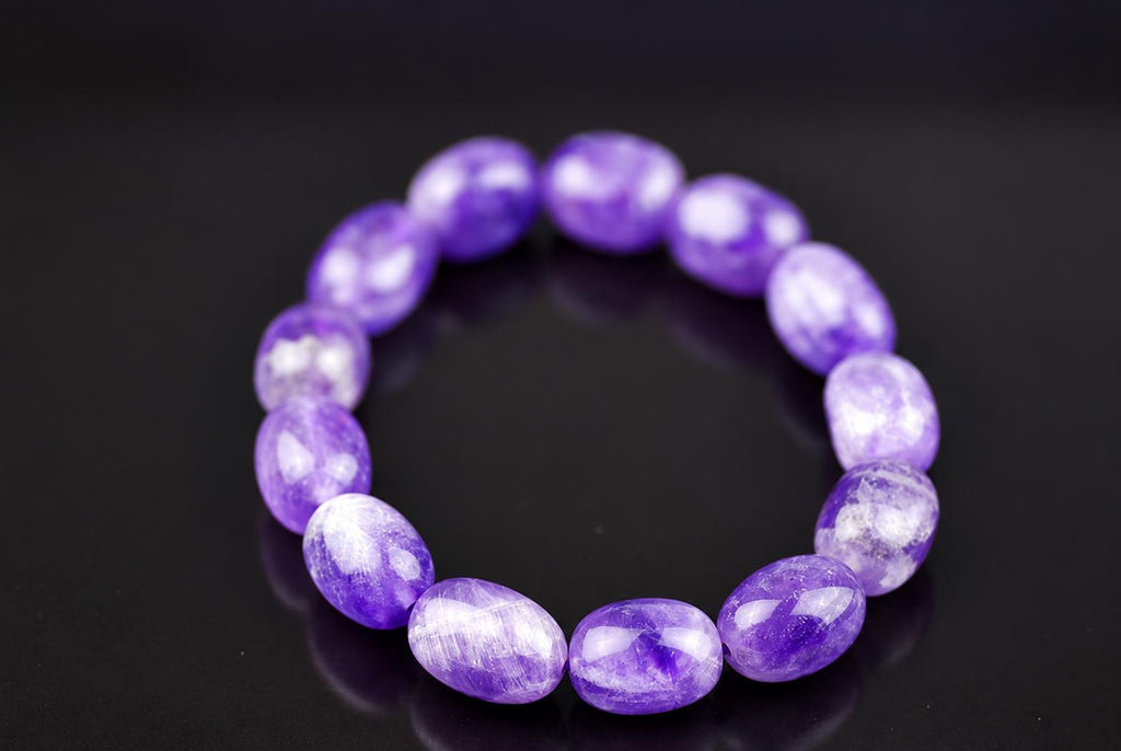 A bracelet of oval beads in purple and white, arranged in a circle on a dark surface.