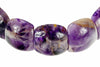 A close-up of a bracelet with polished, irregular beads showing purple amethyst and brownish inclusions on a white background.