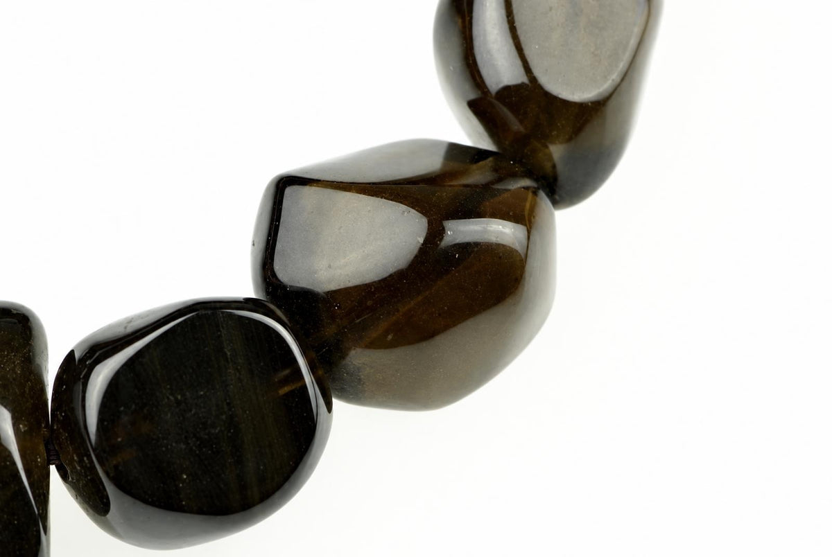A close-up of dark brown, polished beads with a smooth, rounded shape against a white background.