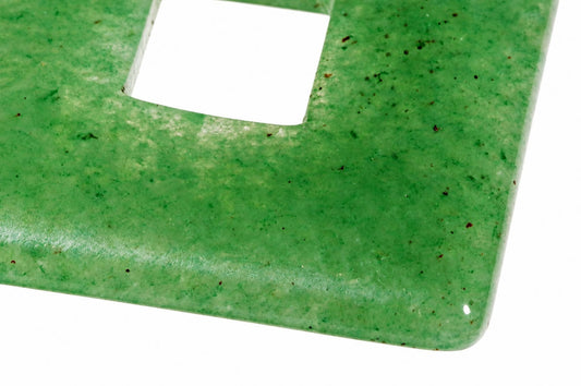 A close-up of a square green aventurine pendant with a central cutout, showing its polished surface and dark speckles.