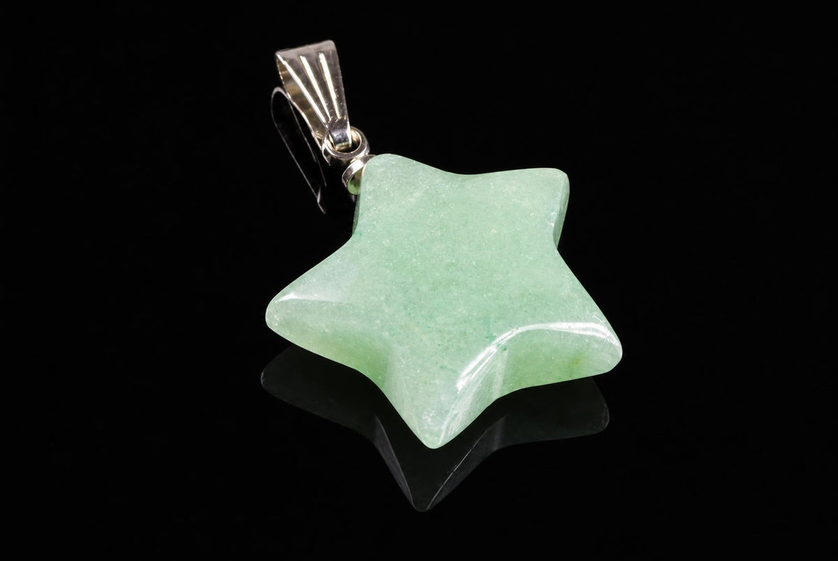 A silver-toned pendant with a five-pointed star aventurine stone on a dark reflective surface.