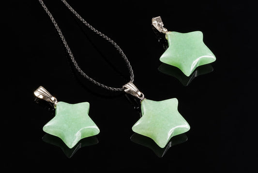 Pale green star-shaped aventurine pendants with silver-tone loops are displayed together on a glossy black surface, with one on a dark cord.