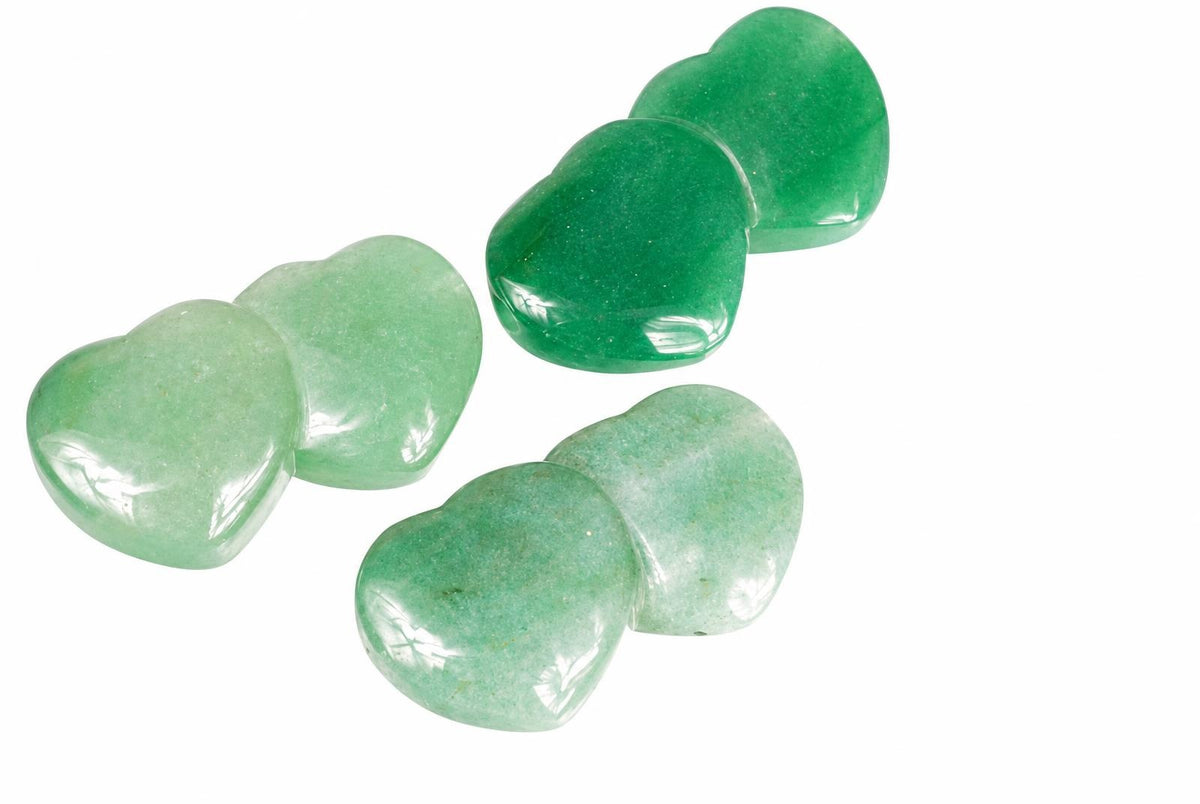 Three polished heart-shaped aventurine stones in pale and dark green shades arranged on a white surface.
