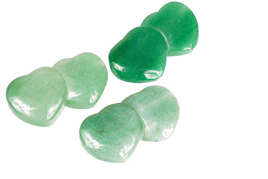 Three polished heart-shaped aventurine stones in pale and dark green shades arranged on a white surface.