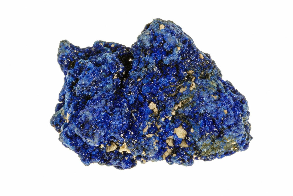 A rough, irregular blue mineral specimen with a granular texture and small light-colored inclusions on a white background.