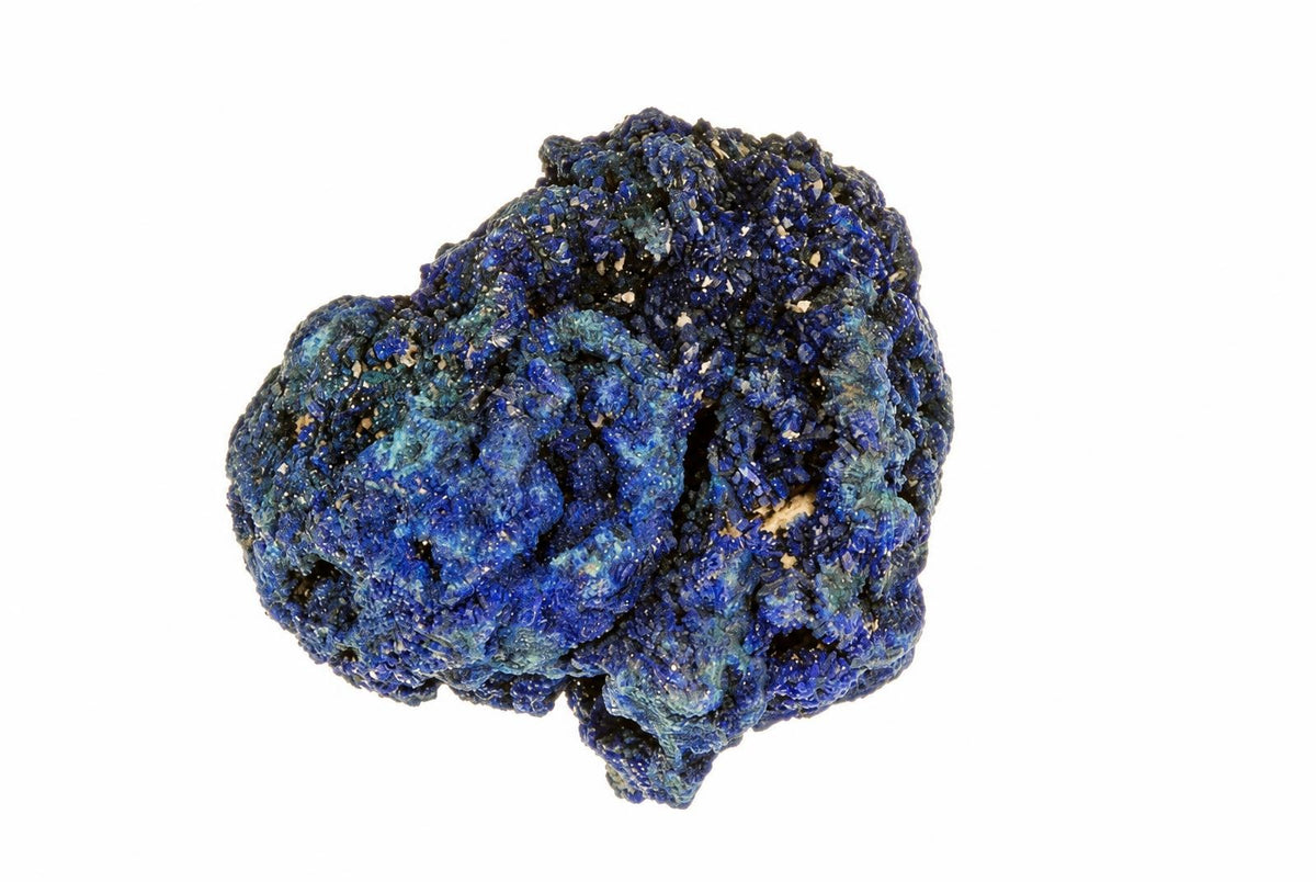 A rough, irregular cluster of deep blue azurite crystals with some lighter patches on a white background.