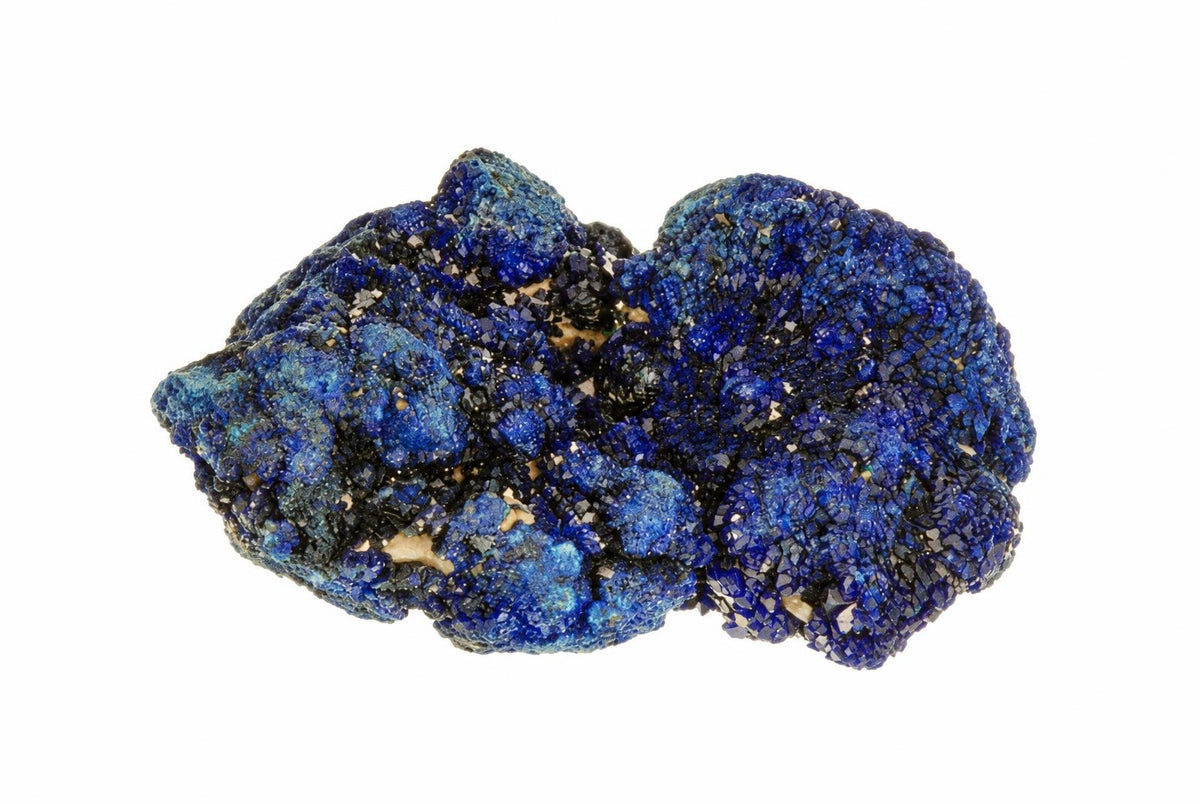 A cluster of azurite crystals showing deep blue and black crystalline textures on a white background.