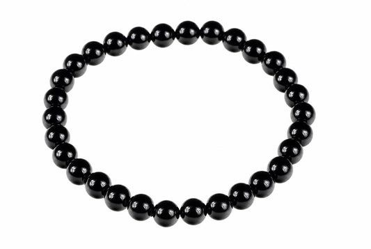 A bracelet made of round black beads arranged in a circle on a white background.