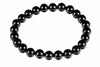 A bracelet made of round, glossy black beads arranged in a circle on a white background.