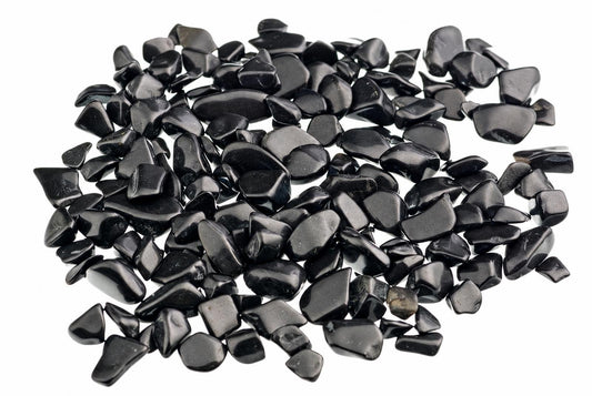 A pile of small, smooth black stones on a white background.
