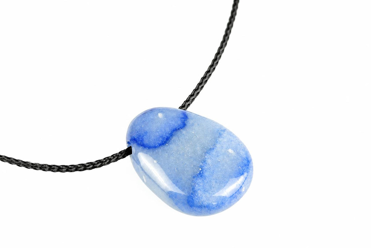 A polished blue quartz pendant with white and dark blue swirls hangs on a black cord against a white background.
