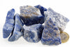 Rough blue and white stone pieces with mottled surfaces are grouped beside a coin on a white background.