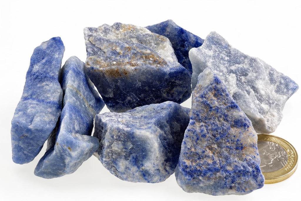 Rough blue and white stone pieces with mottled surfaces are grouped beside a coin on a white background.