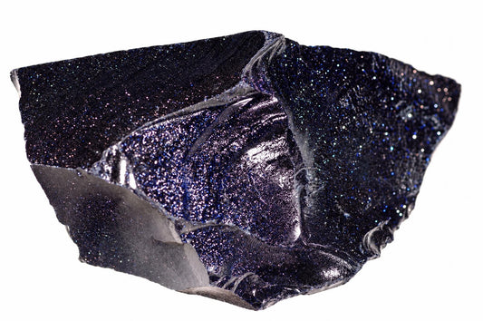 A raw, irregular shard of dark blue material with a glittering surface and silver-toned metallic highlights on its edges.