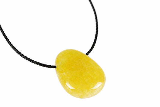 A yellow calcite pendant with a smooth, oval shape hangs from a black cord against a white background.