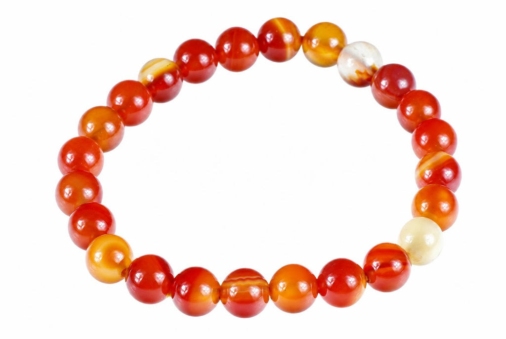 A bracelet of round beads in red, orange, yellow and cream tones on a white background.