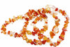 A necklace of irregular carnelian chips in red, orange, yellow and pale tones on a white surface.