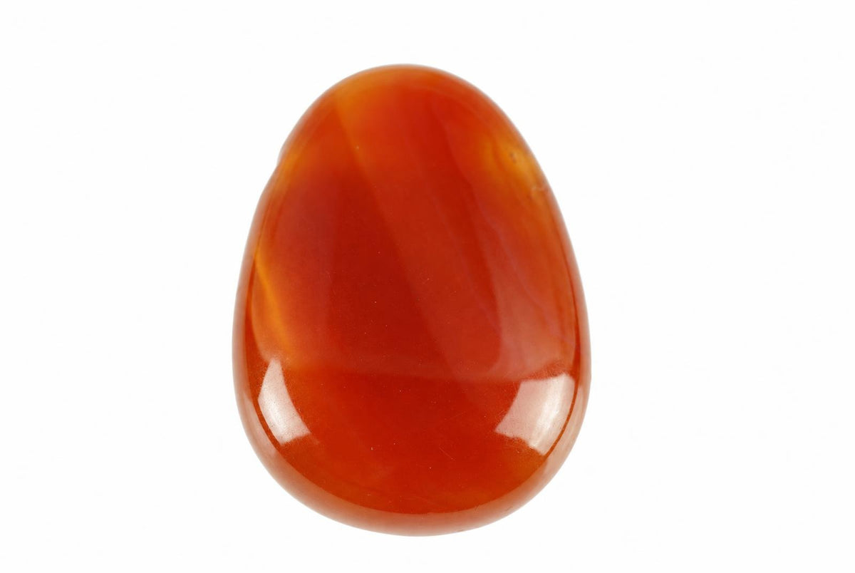 A polished, teardrop-shaped carnelian stone with smooth red and orange bands on a white background.