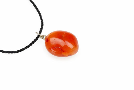 A polished, oval-shaped orange pendant on a black cord against a white background.