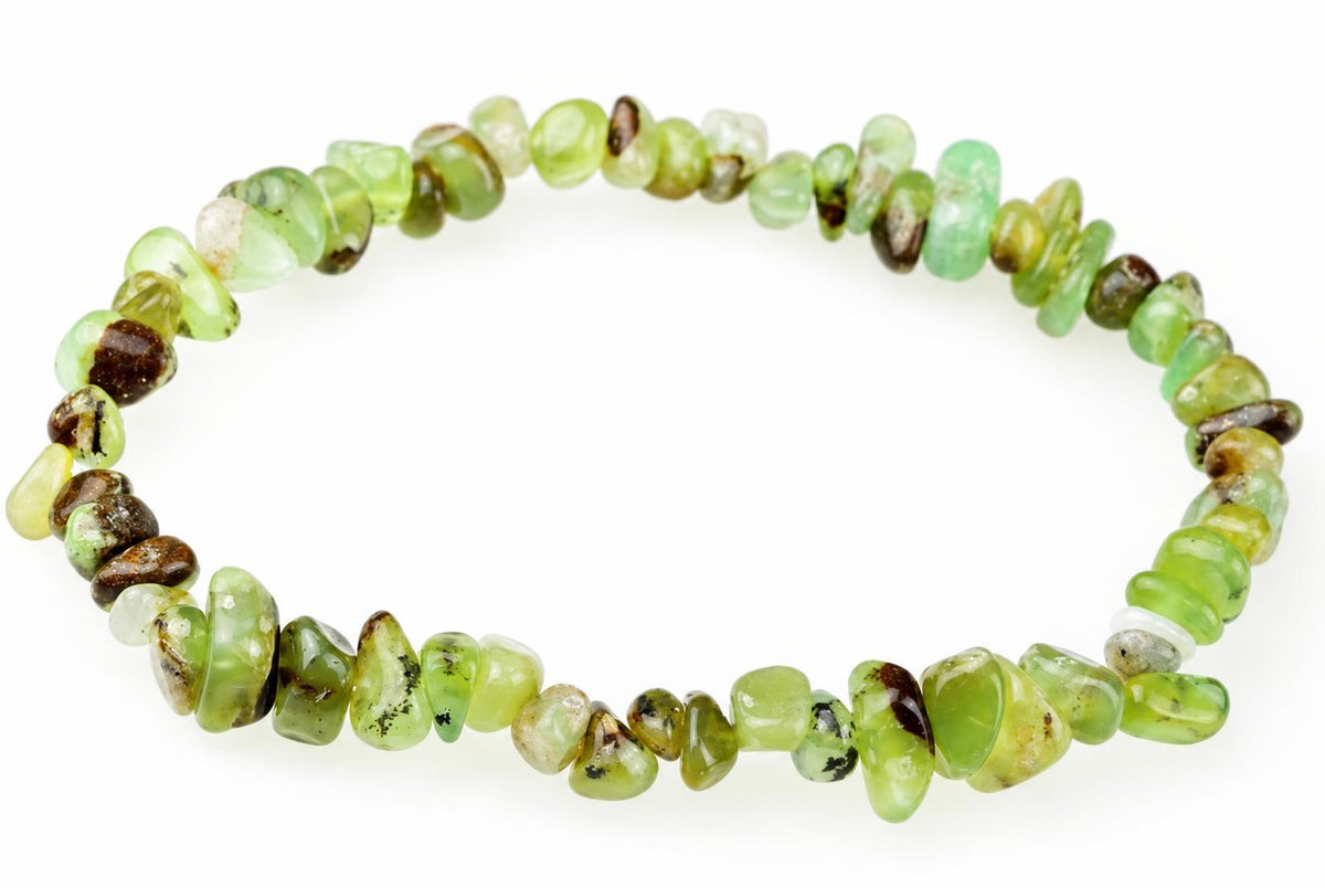 A bracelet made of irregular chips in light green, dark brown and pale tones arranged on a white surface.