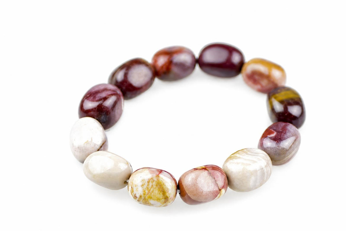 Bracelet of polished rounded beads in cream, burgundy, pink and mustard yellow, arranged in an oval on a white background and viewed at an angle.