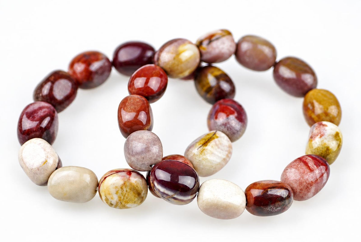 Polished rounded bead bracelet arranged in overlapping loops on a white background, with burgundy, rust red, mustard yellow, cream and mauve beads showing varied natural markings.
