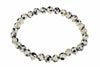 A bracelet made of round beads with a cream background and dark spots, arranged in a circle on a white surface.